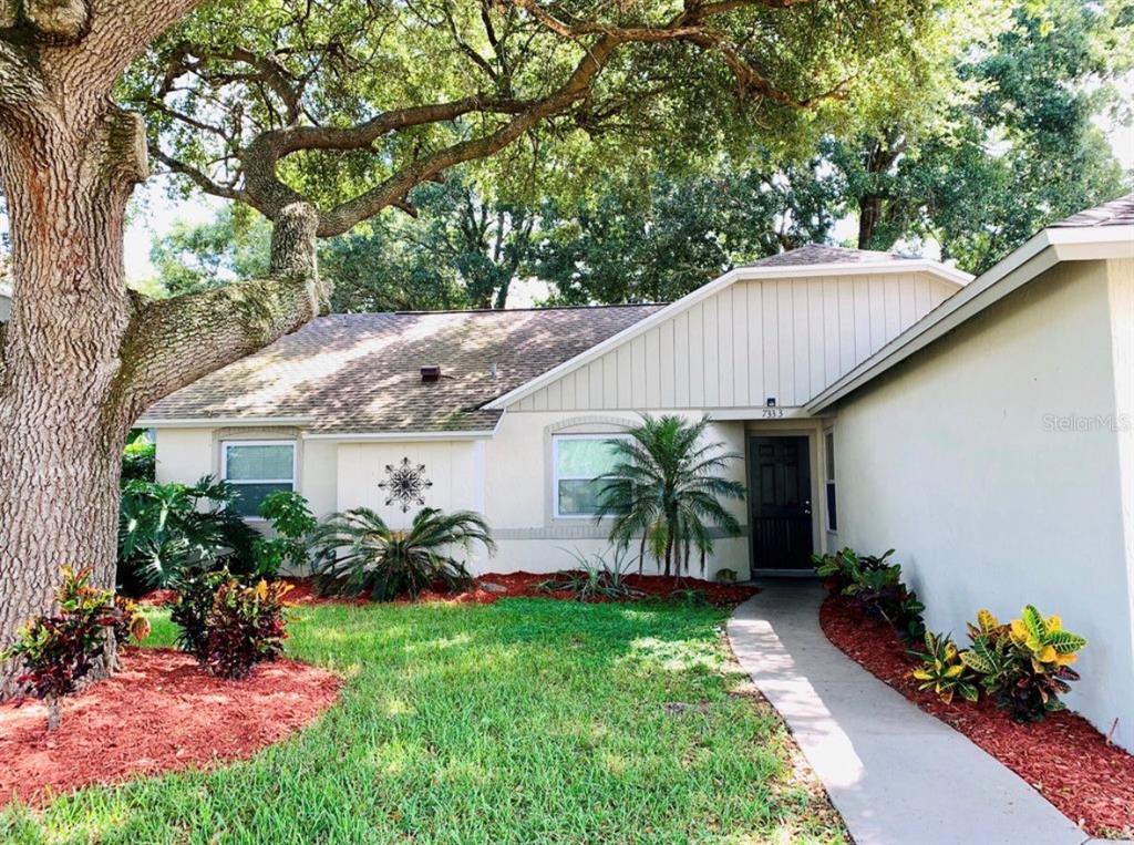 A single-story house with a light-colored exterior, a walkway, and a large tree in front — 7333 RADIANT CIRCLE, ORLANDO, FL