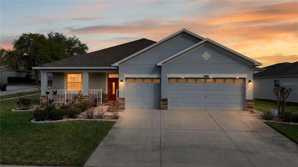 A single-story house with a gray exterior, a two-car garage, and a front porch — 5269 ROYCE DRIVE, MOUNT DORA, FL