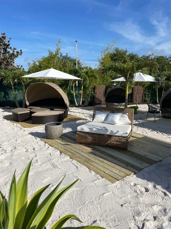 Outdoor lounge area with wicker daybeds, white umbrellas, and wooden platforms on a sandy beach — 6... K PARKWAY, ORLANDO, FL