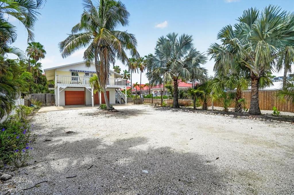 A two-story house with a gravel driveway and several palm trees in the yard — 524 SPRING AVENUE, ANNA MARIA, FL