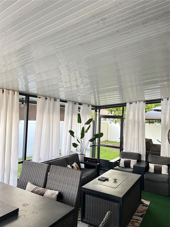 A screened-in patio features a white paneled ceiling, wicker furniture, and white curtains — 12226 FAIRLAWN DRIVE, RIVERVIEW, FL