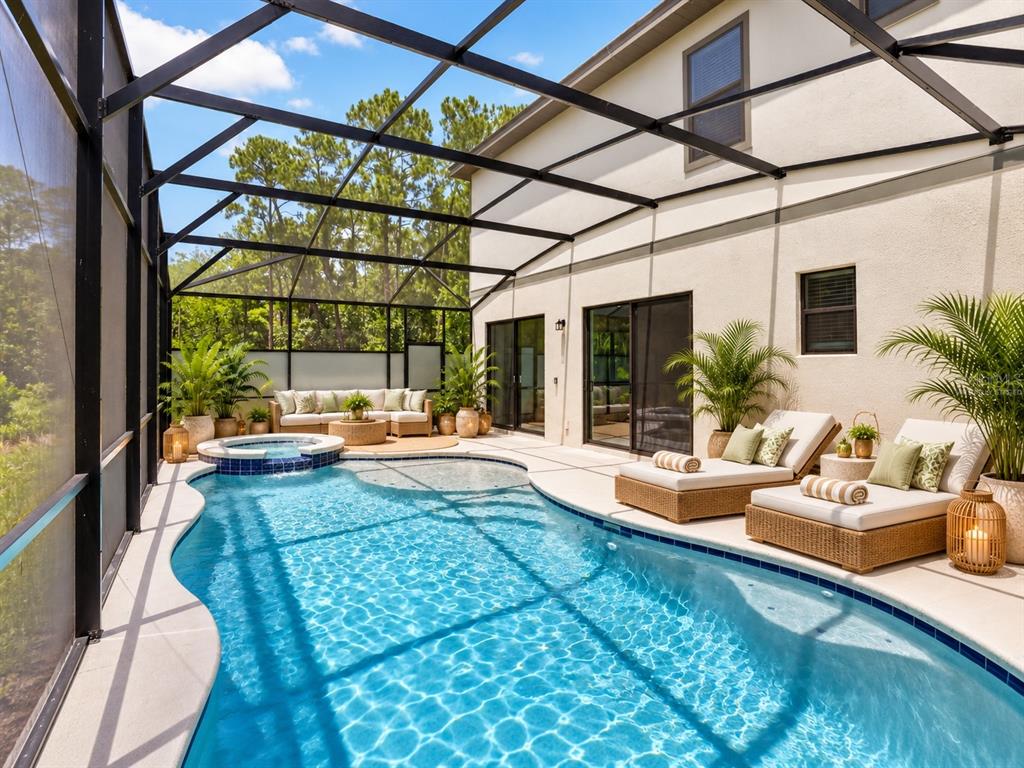 A backyard view of a two-story house with a screened-in pool and spa — 1242 BUTTERFLY ORCHID ROAD, DAVENPORT, FL