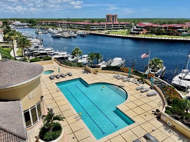 An elevated view shows a swimming pool on a patio overlooking a boat-filled marina — 3321 SUNSET KEY CIRCLE UNIT 102, PUNTA GORDA, FL