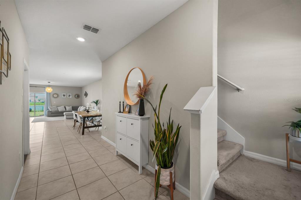 A tiled entryway leads to an open-concept living area with stairs on the right — 31575 BARREL WAVE WAY, WESLEY CHAPEL, FL