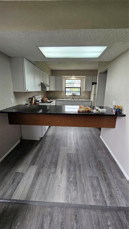 A kitchen features white cabinets, stainless steel appliances, granite countertops, and a white subway tile backsplash — 3626 WILLOW OAK ROAD, MULBERRY, FL