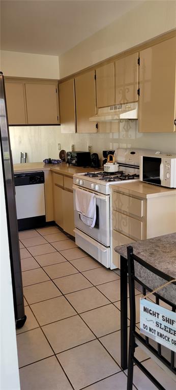 A kitchen with beige cabinets, white appliances, and light-colored tile flooring — 2218 ABBEY ROAD, WINTER HAVEN, FL
