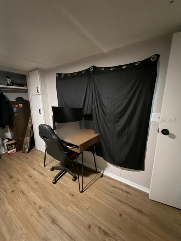 A room with wood-look flooring, a desk with a gaming chair, and black curtains — 427 POLK AVENUE, ORANGE PARK, FL