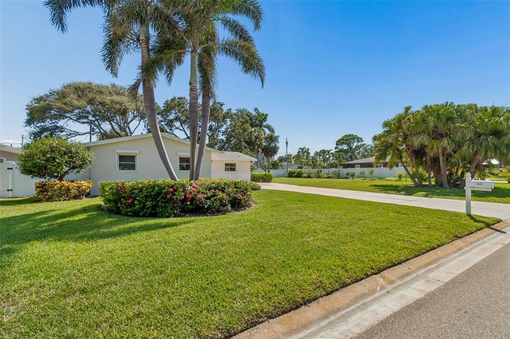 A single-story house with a large lawn, palm trees, and a paved driveway — 114 8TH STREET, BELLEAIR BEACH, FL