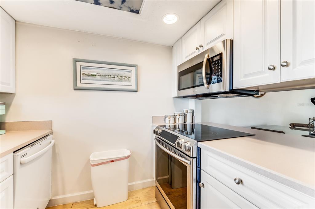 A kitchen features white cabinets, stainless steel appliances, and a light-colored countertop — 935 OCEAN SHORE BOULEVARD UNIT 303, ORMOND BEACH, FL