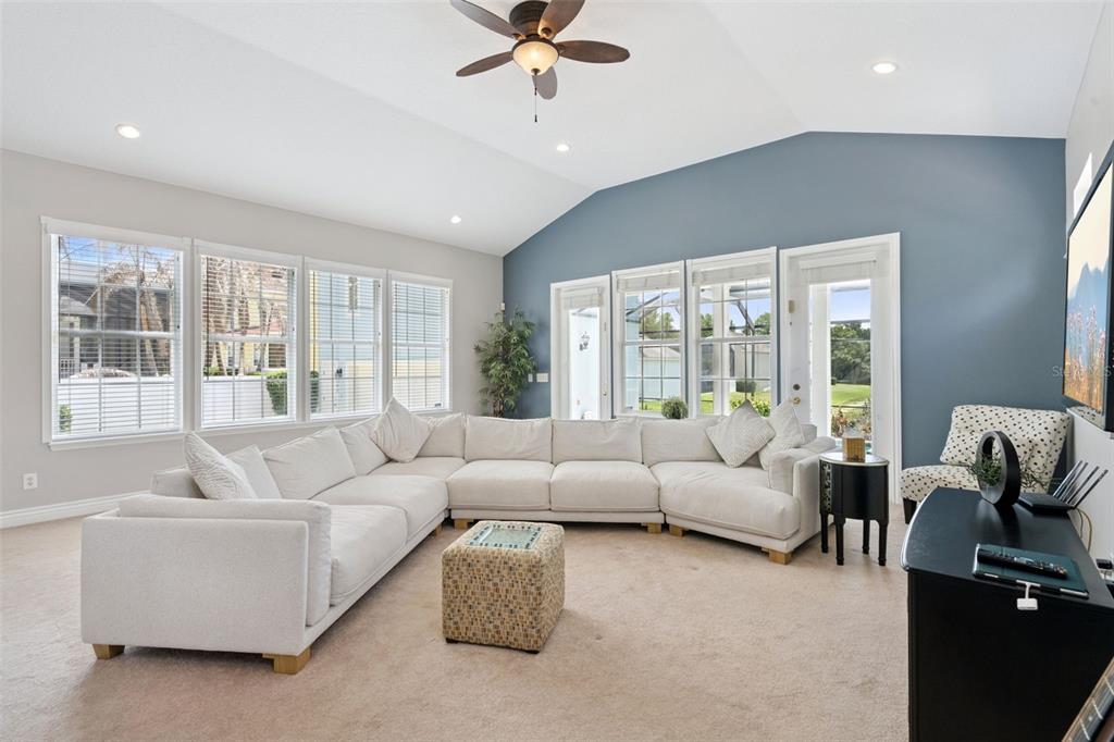 A living room with hardwood floors, a leather armchair, and a built-in wooden bar area — 930 CROTON ROAD, CELEBRATION, FL