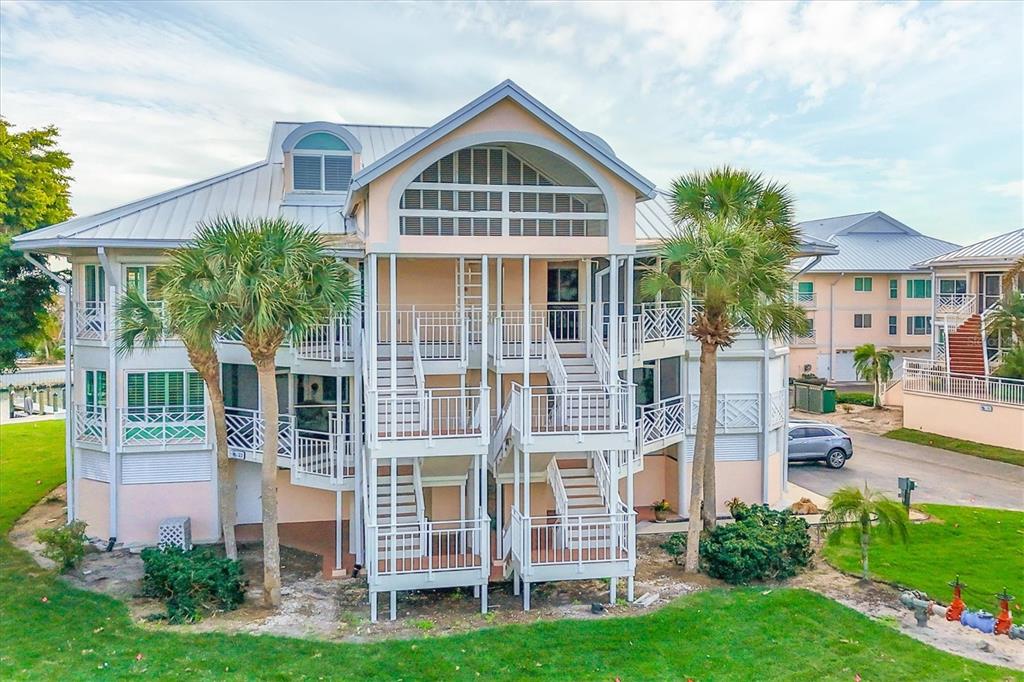 An exterior view of a multi-story residential building with white stairs and balconies — 11000 PLACIDA ROAD UNIT 2103, PLACIDA, FL