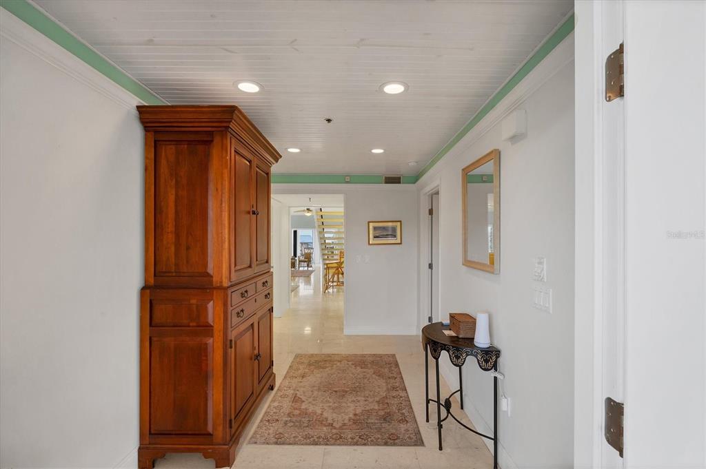 A hallway features a large wooden armoire, a console table, and a patterned area rug — 11000 PLACIDA ROAD UNIT 2103, PLACIDA, FL