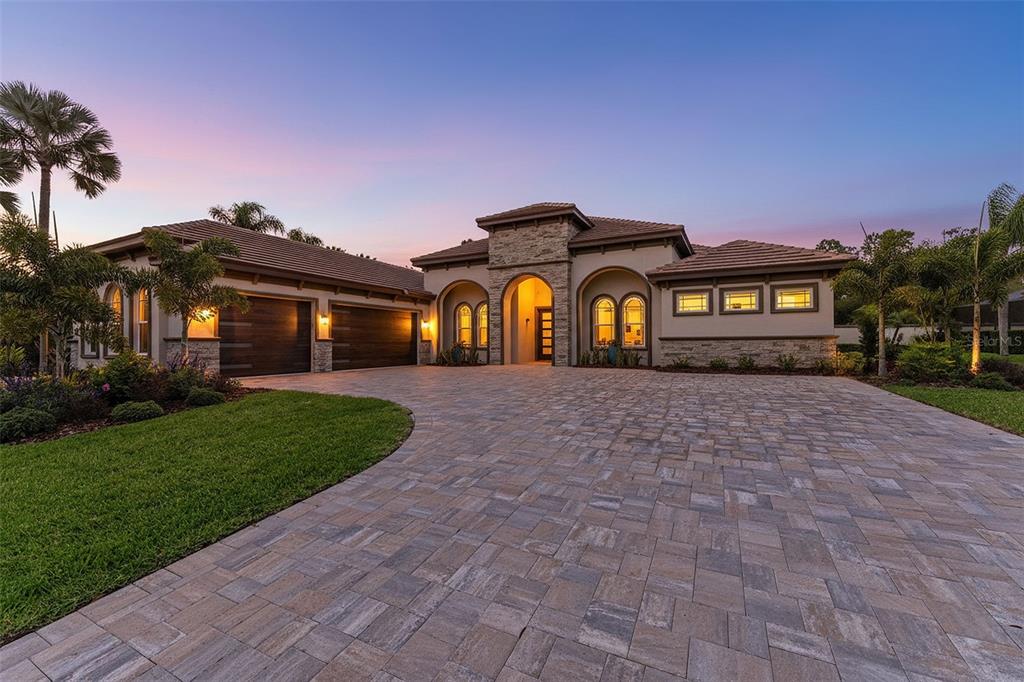 A covered patio features a swimming pool with a tanning ledge and outdoor seating area — 10700 PONTOFINO CIRCLE, TRINITY, FL