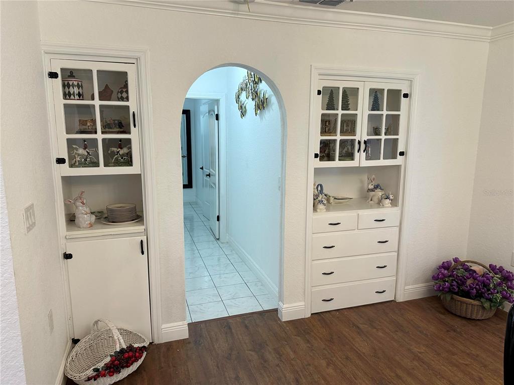 A room features two built-in white cabinets flanking an arched doorway leading to a hallway — 17067 NW GAINESVILLE ROAD, REDDICK, FL