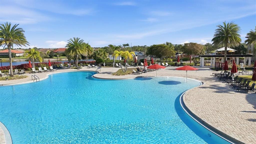 A large outdoor swimming pool is surrounded by a paved deck with lounge chairs — 20229 LAGENTE CIRCLE, VENICE, FL
