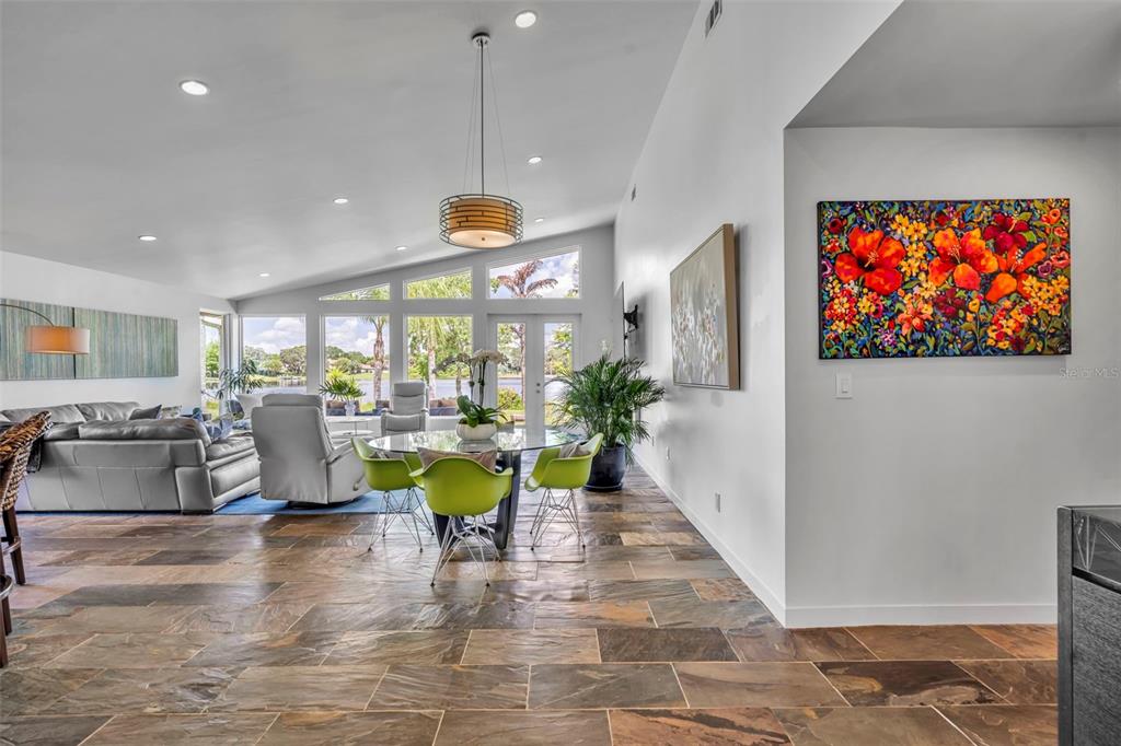 A modern front entryway features a wood door with frosted glass panels and potted plants — 1841 LAKE SPIER DRIVE, WINTER PARK, FL
