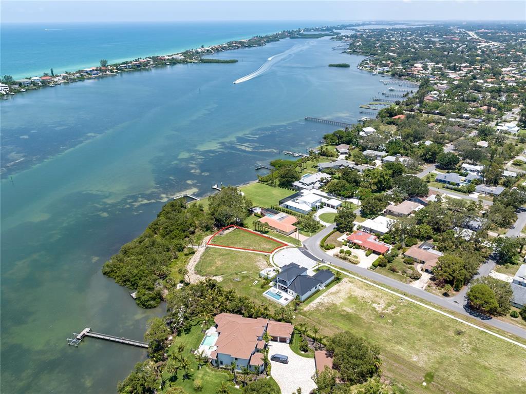 An aerial view shows a vacant waterfront lot outlined in red near a residential street — 1461 BAYSHORE ROAD, NOKOMIS, FL