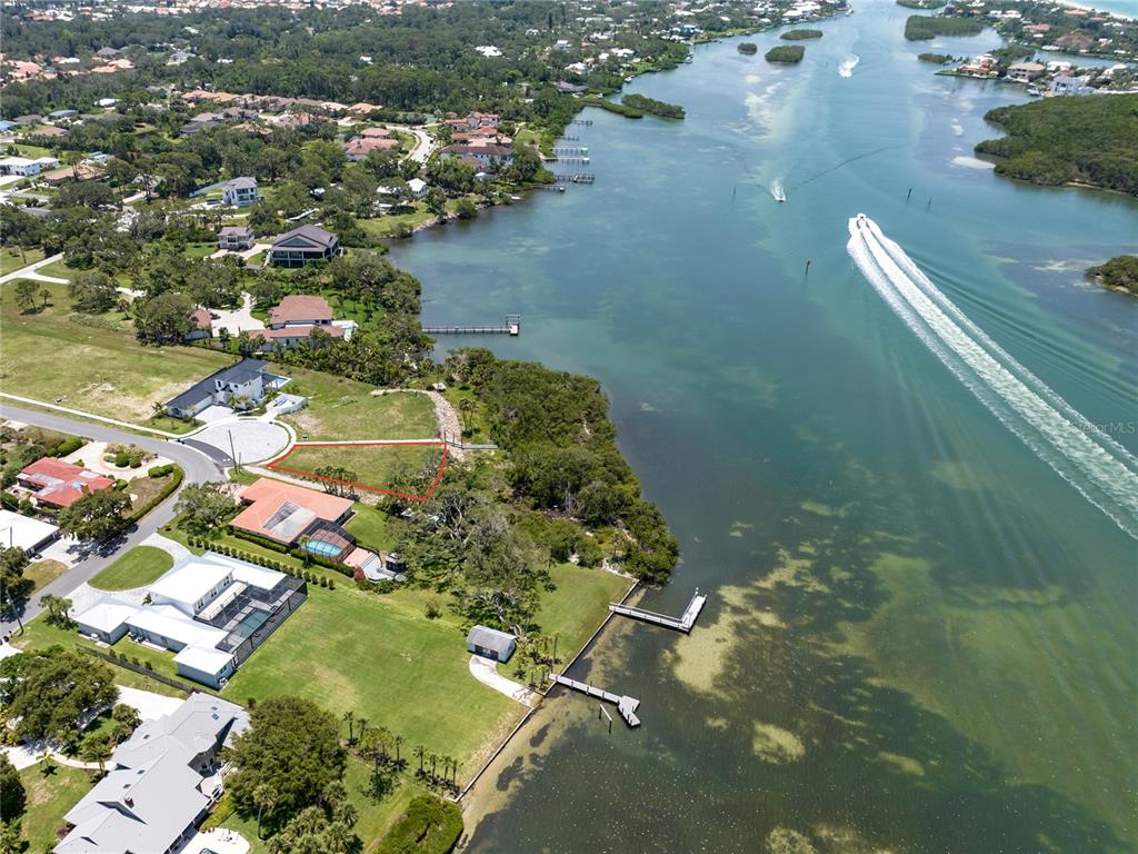An aerial view shows a vacant waterfront lot outlined in red near a residential neighborhood — 1461 BAYSHORE ROAD, NOKOMIS, FL