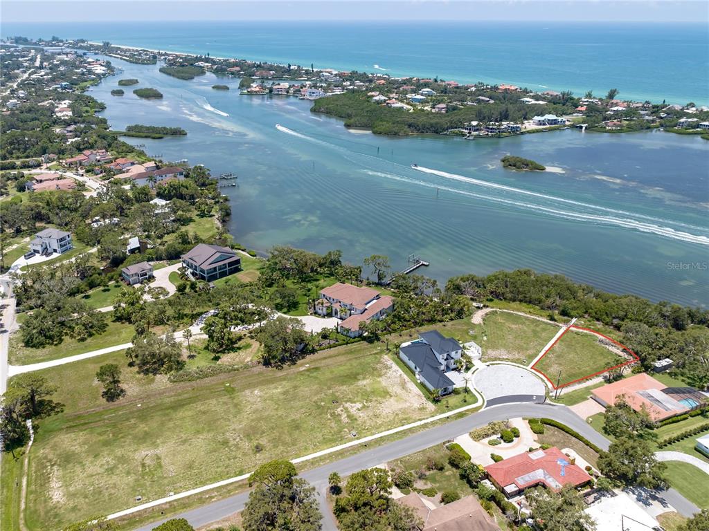 An aerial view shows a vacant waterfront lot outlined in red near a residential cul-de-sac — 1461 BAYSHORE ROAD, NOKOMIS, FL