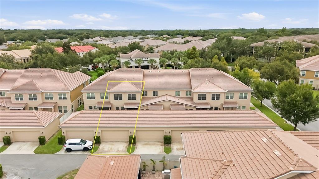 An aerial view shows a multi-story townhouse complex with tile roofs and attached garages — 11425 BROWNSTONE STREET, WINDERMERE, FL