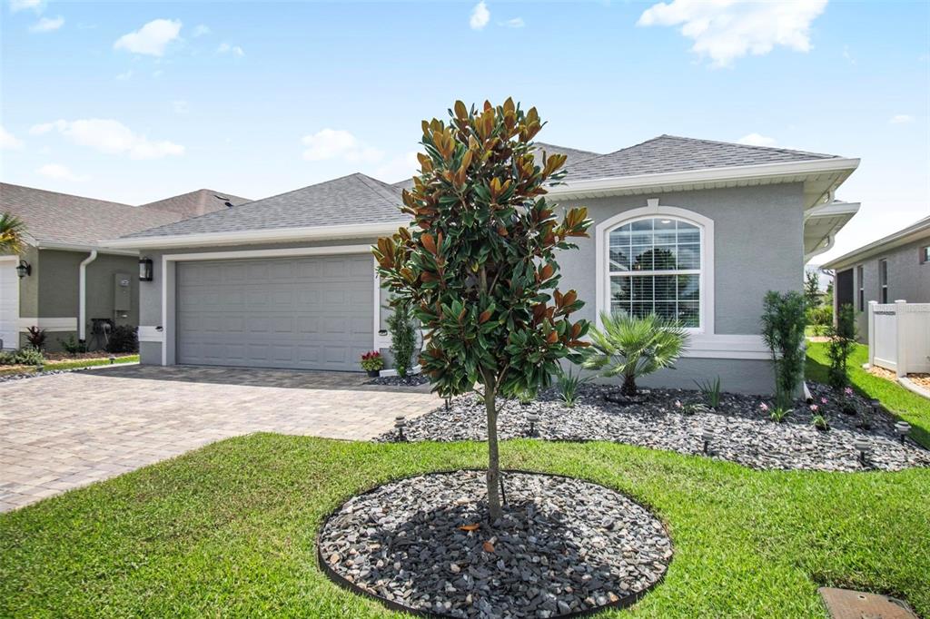 A gray single-story house with a two-car garage, a paved driveway, and a landscaped front yard — 7 TIDEWAY TRAIL, PALM COAST, FL