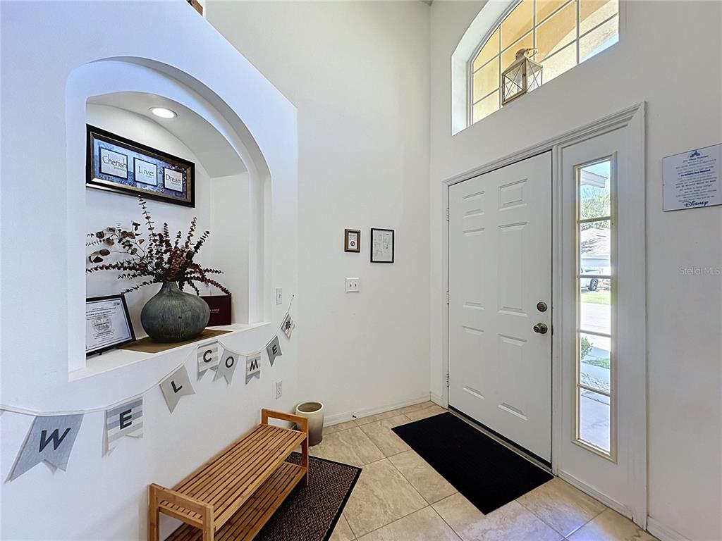 An entryway features a tiled floor, a white front door, and a recessed wall niche — 2817 KOKOMO LOOP, HAINES CITY, FL