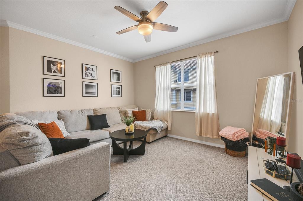 A living room features a beige sectional sofa, a round coffee table, and a ceiling fan — 2637 LEGACY VILLAS DRIVE UNIT 2637, MAITLAND, FL