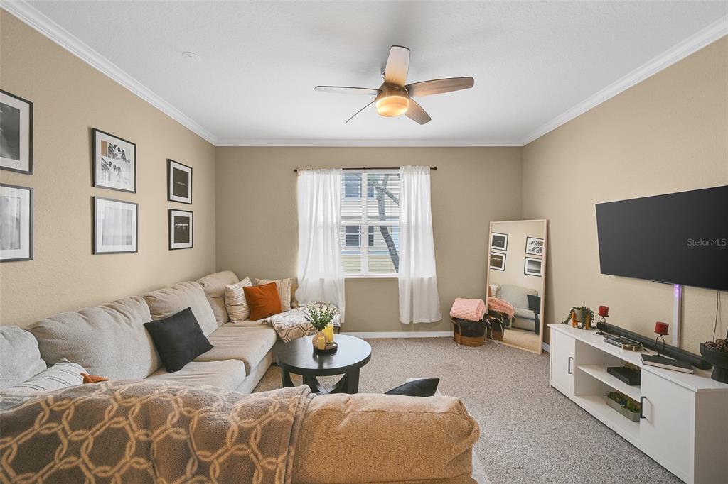 A living room features a sectional sofa, a television, a coffee table, and a ceiling fan — 2637 LEGACY VILLAS DRIVE UNIT 2637, MAITLAND, FL
