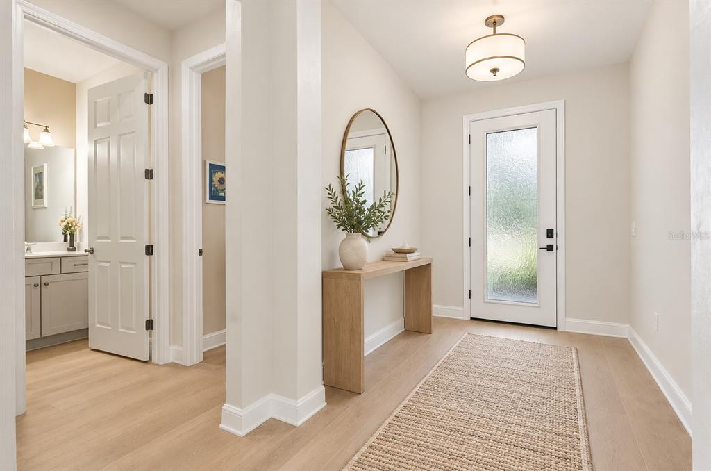 A blue front door with a glass insert sits at the end of a paved entryway — 19556 PETRINO STREET, VENICE, FL