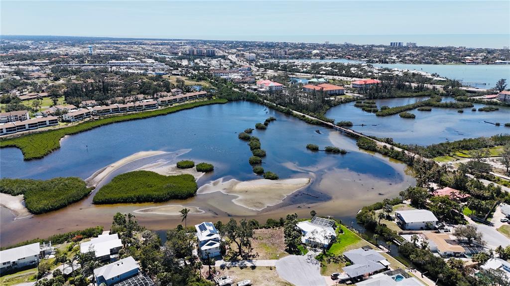 An aerial view shows a coastal residential area with a large tidal lagoon and mangroves — 808 SUNCREST DRIVE, NOKOMIS, FL