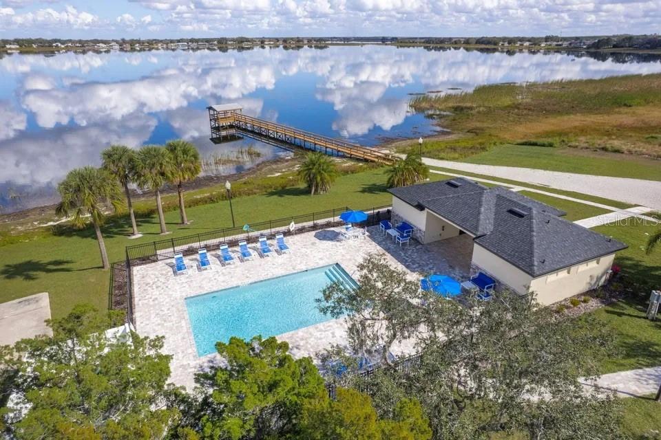 A wooden pier with a covered gazebo extends over a calm lake under a cloudy sky — 998 GRAND LAKE BOULEVARD, AVON PARK, FL