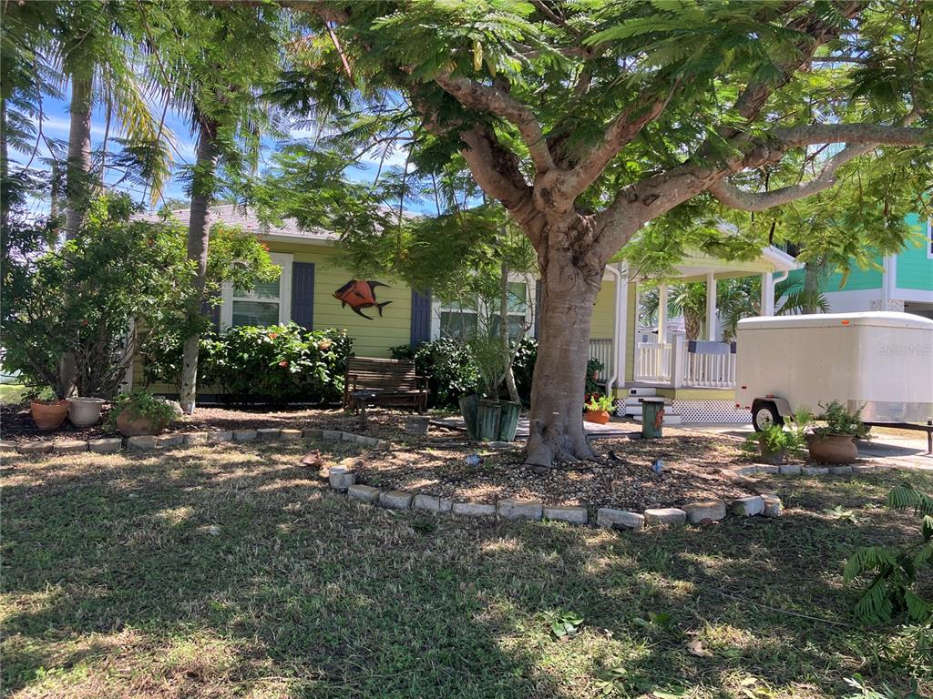 A front porch with gray steps, a light green exterior, and an orange storm door — 3008 DUPONT STREET S, GULFPORT, FL