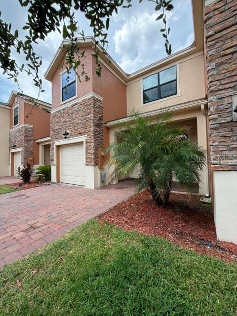 A kitchen features dark wood cabinets, a breakfast bar with wood paneling, and tile flooring — 1743 PORTOFINO MEADOWS BOULEVARD, ORLANDO, FL