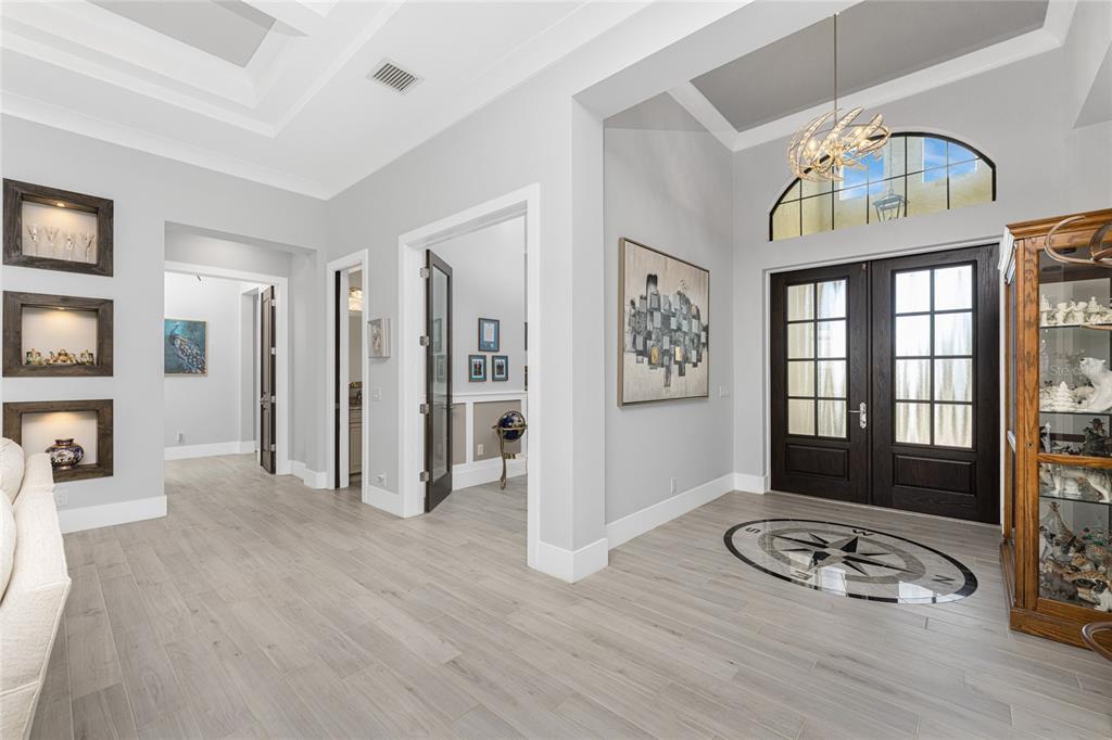 A bright foyer features a compass rose floor inlay, dark double doors, and light flooring — 265 SEVERIN RD, PORT CHARLOTTE, FL