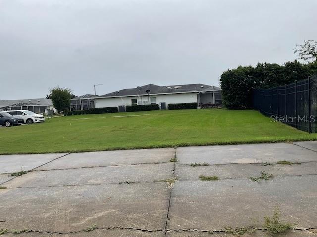 A grassy lot sits in front of a one-story residential building under a cloudy sky — WILLOW DRIVE, LEESBURG, FL