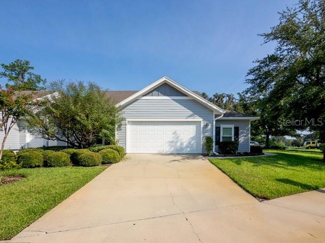 A light blue house with a two-car garage and a concrete driveway under a clear sky — 12604 NW 11 PLACE, NEWBERRY, FL