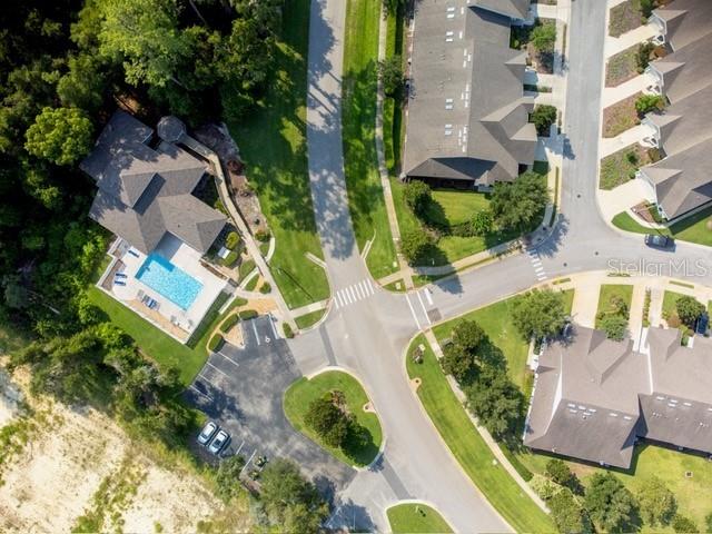 This aerial view shows a residential neighborhood with houses, a swimming pool, and roads — 12604 NW 11 PLACE, NEWBERRY, FL