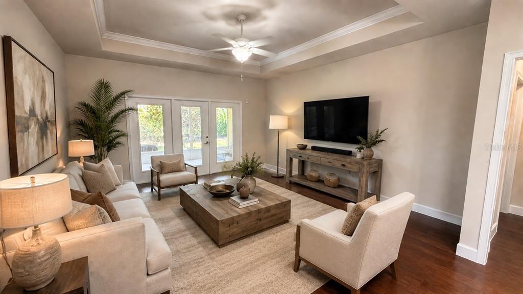 A living room features a tray ceiling, a large wooden coffee table, and a television console — 12604 NW 11 PLACE, NEWBERRY, FL