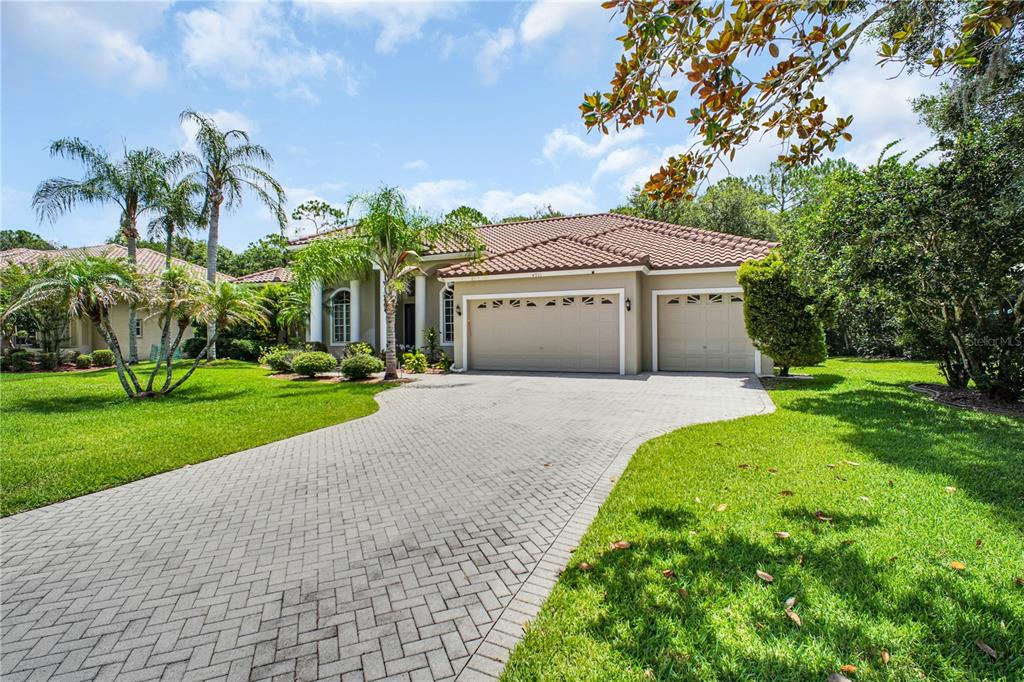A single-story house with a tiled roof, three-car garage, and a paved driveway — 4931 TURTLE CREEK TRAIL, OLDSMAR, FL