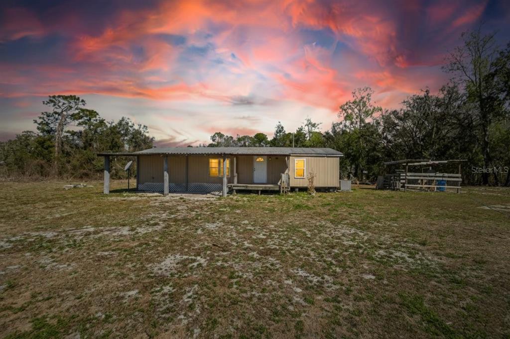 A single-story manufactured home with a front porch sits on a large, grassy lot — 35238 MANUEL STREET, WEBSTER, FL