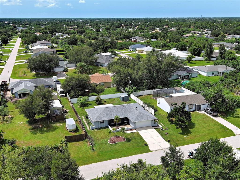 An aerial view shows a single-story suburban house with a gray roof and a driveway — 11081 MAGDALENA AVENUE, ENGLEWOOD, FL
