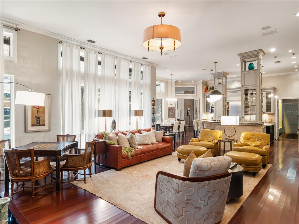 A spacious living room features a leather sofa, yellow armchairs, and hardwood floors — 16211 VILLARREAL DE AVILA, TAMPA, FL