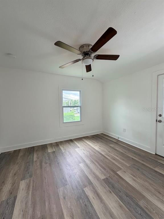 An empty room features white walls, a ceiling fan, and wood-look vinyl plank flooring — 302.5 S 12TH, LEESBURG, FL