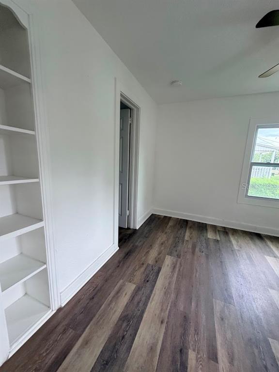 A room with white walls, wood-look flooring, a built-in bookshelf, and a window — 302.5 S 12TH, LEESBURG, FL
