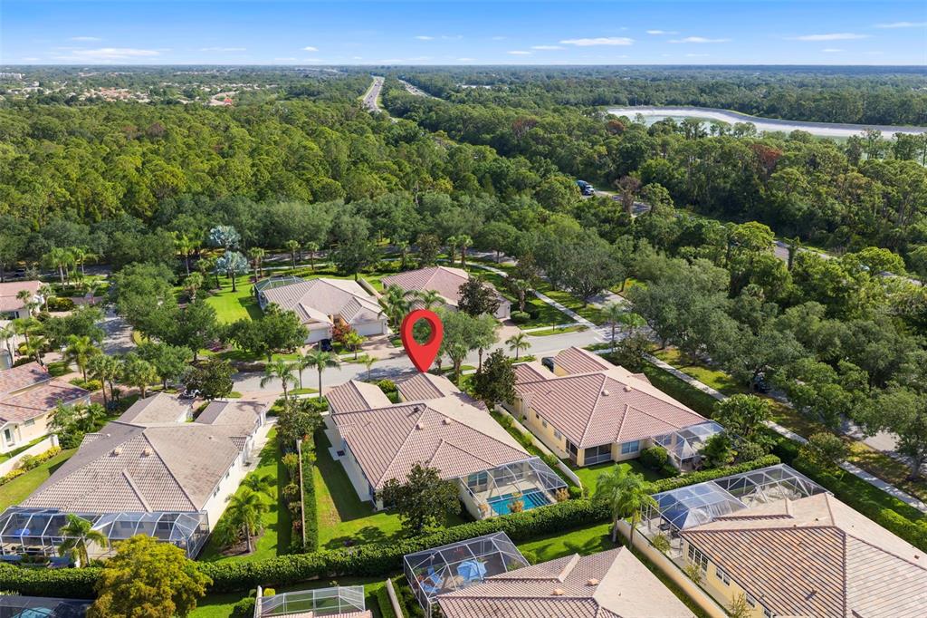 An aerial view shows a residential neighborhood with houses featuring tiled roofs and swimming pools — 5793 ITHACA WAY, SARASOTA, FL