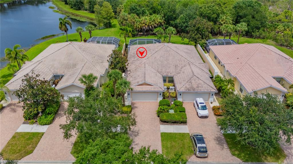 An aerial view shows three attached houses with tiled roofs, driveways, and screened-in back patios — 8012 CAMMINARE DRIVE, SARASOTA, FL