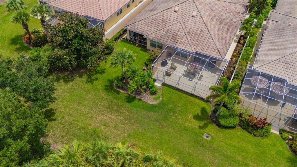 An aerial view shows the backyards and screened-in lanais of several suburban homes — 8012 CAMMINARE DRIVE, SARASOTA, FL