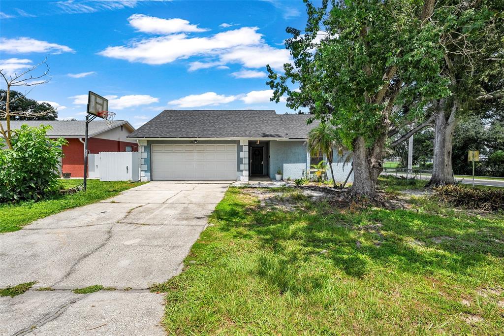 The exterior of a blue house features a white garage door and a covered entryway — 3878 FEATHER DRIVE, LAKELAND, FL