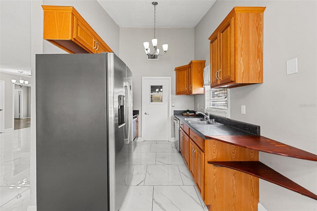 A living room with white marble-look tile floors, gray walls, and a brick fireplace — 3878 FEATHER DRIVE, LAKELAND, FL