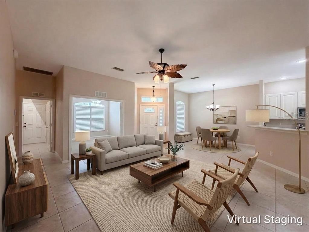A virtually staged living and dining area with tile floors, a ceiling fan, and neutral walls — 11734 SE 173RD LANE ROAD, SUMMERFIELD, FL